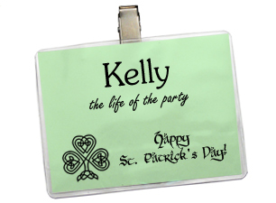 Green insert inside a badge holder with a clip fastener attached to the back. The insert has a name and holiday themed text and image printed on it.