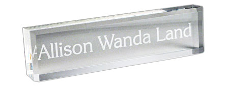 Clear acrylic desk nameplate with engraved text.