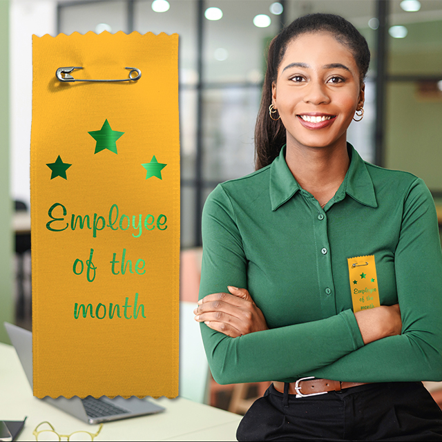 Gold badge ribbon with metallic green text celebrating an employee of the month.