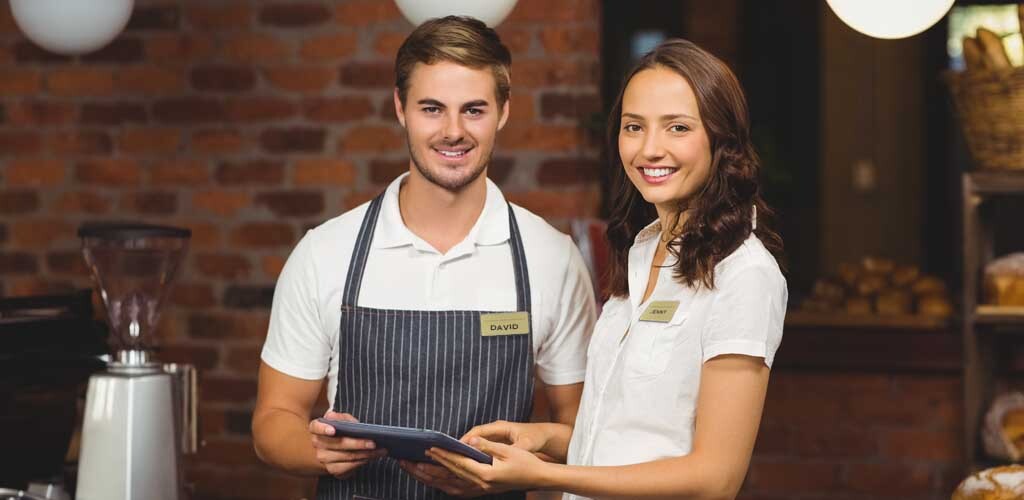 Two restaurant employees wearing name tags with first names only, which is meant to help employees feel safe wearing name tags.