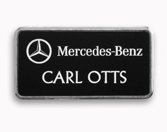 A black name tag with an engraved white logo and text.