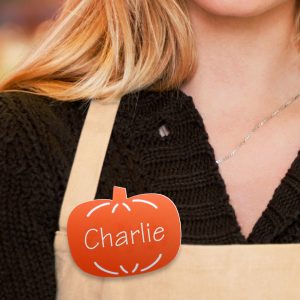 A retail employee wearing a custom shaped name tag as part of the business' store decorations.