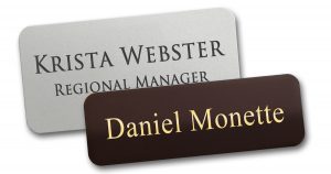 Engraved metal name tags with custom names and titles.