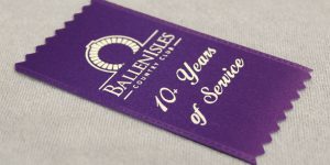 High-quality purple custom graphic badge ribbon for celebrating multiple years in service.