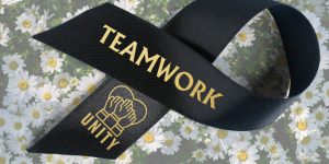 Custom black ribbon roll with gold imprinted text and graphic to encourage team work and summer fun.