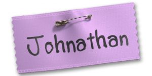 Lavender blank badge ribbon with a pin and a handwritten name for a child's games.