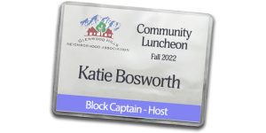 A vinyl badge holder with a printed insert with the name of a block captain for a community luncheon.