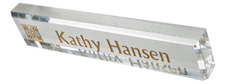 Clear acrylic desk nameplate with engraved text and logo.